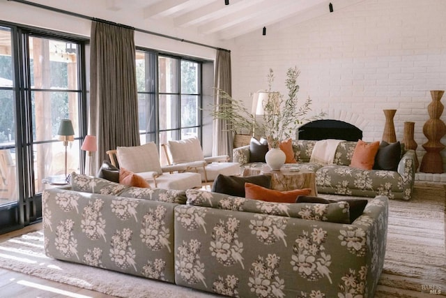 interior space featuring lofted ceiling with beams, brick wall, and a fireplace