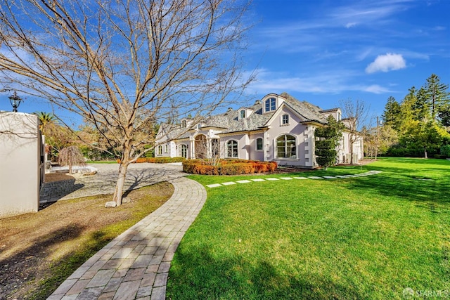 view of front of property featuring a front lawn and stucco siding