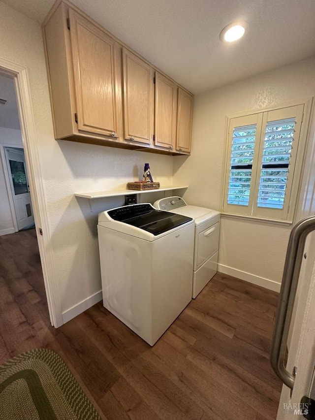 laundry area featuring independent washer and dryer, cabinets, and dark hardwood / wood-style flooring