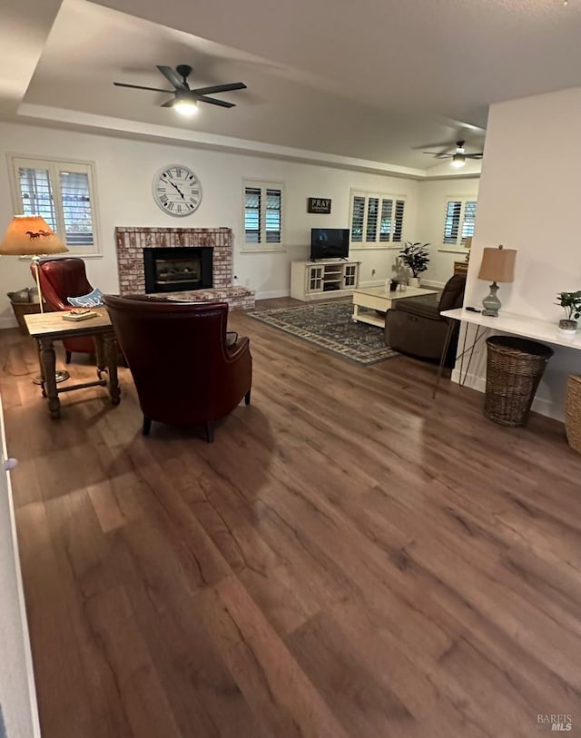 living room with a fireplace, a wealth of natural light, and dark hardwood / wood-style floors