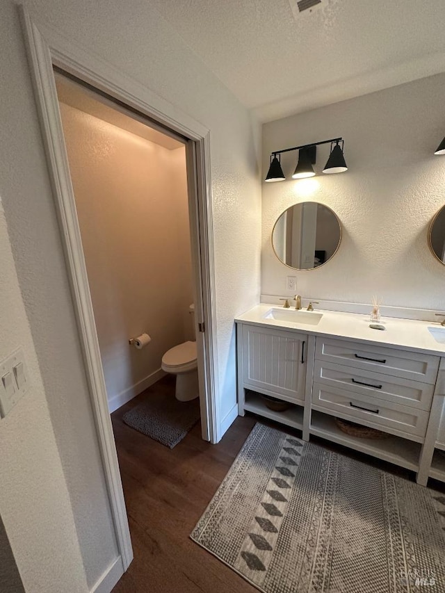 bathroom featuring wood-type flooring, vanity, and toilet