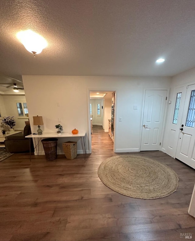 entryway with ceiling fan, dark hardwood / wood-style floors, and a textured ceiling