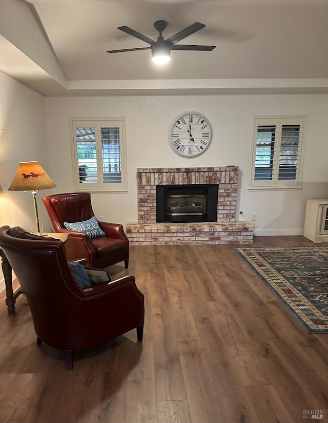 living room with wood-type flooring, a fireplace, and ceiling fan