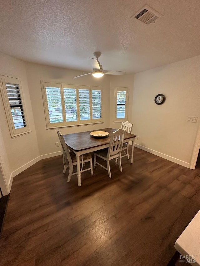 dining room with ceiling fan, a textured ceiling, and dark hardwood / wood-style flooring