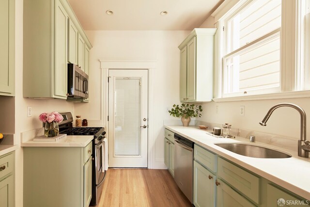 1600 Anza St, San Francisco, CA 94118 - kitchen with stainless steel appliances, light countertops, light wood finished floors, and green cabinetry