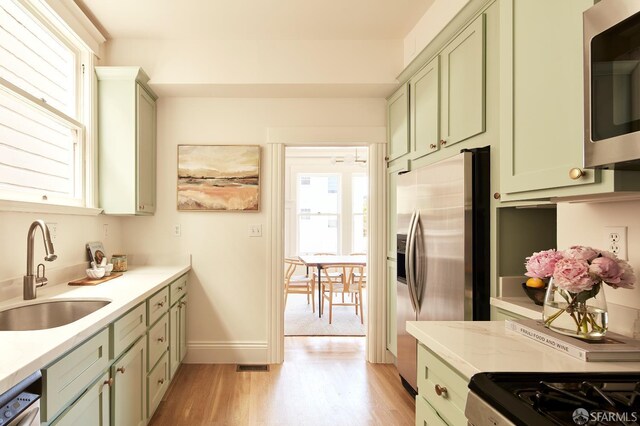 1600 Anza St, San Francisco, CA 94118 - kitchen featuring green cabinetry, stainless steel appliances, light wood finished floors, and healthy amount of natural light
