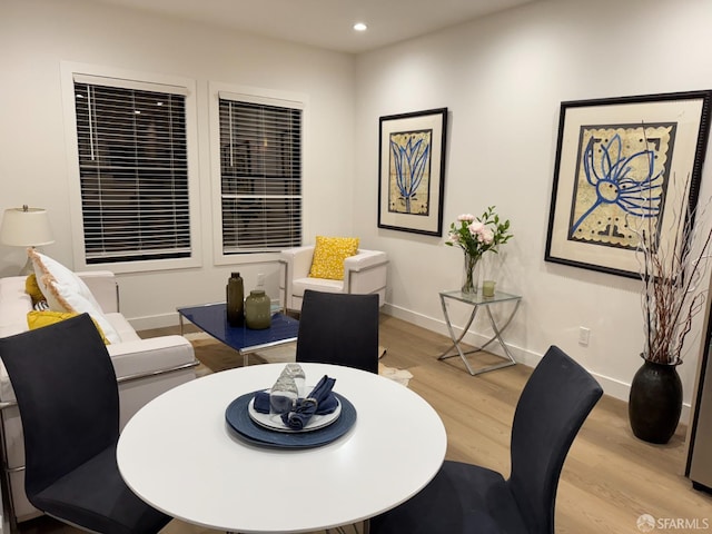 dining space featuring light wood finished floors, baseboards, and recessed lighting