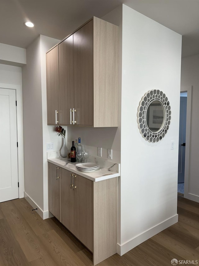 kitchen with recessed lighting, light countertops, baseboards, and wood finished floors