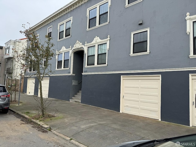 view of property with an attached garage and stucco siding