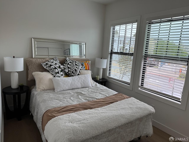 bedroom with baseboards and wood finished floors