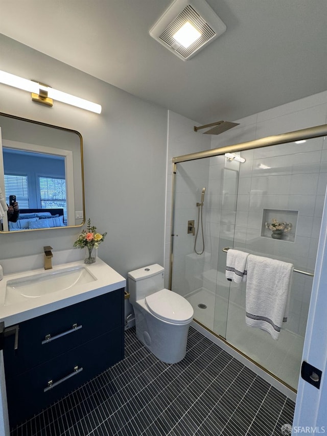 full bath with a stall shower, visible vents, vanity, and toilet