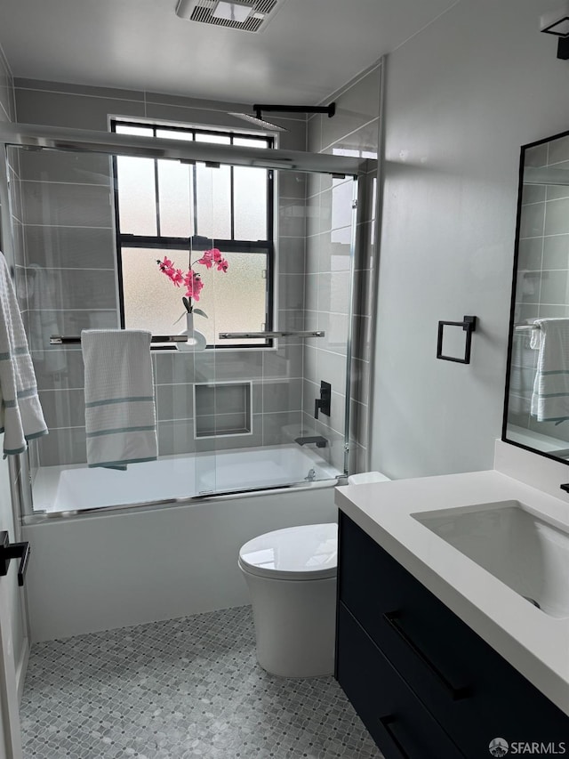 full bathroom with enclosed tub / shower combo, toilet, visible vents, and vanity