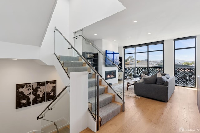 131 Missouri St Unit 402, San Francisco, CA 94107 - staircase with wood finished floors, a wall of windows, recessed lighting, and a lit fireplace