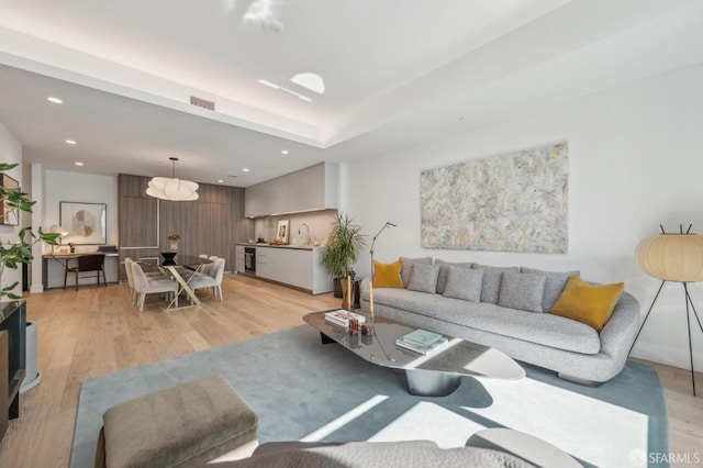living room with recessed lighting, light wood finished floors, and visible vents