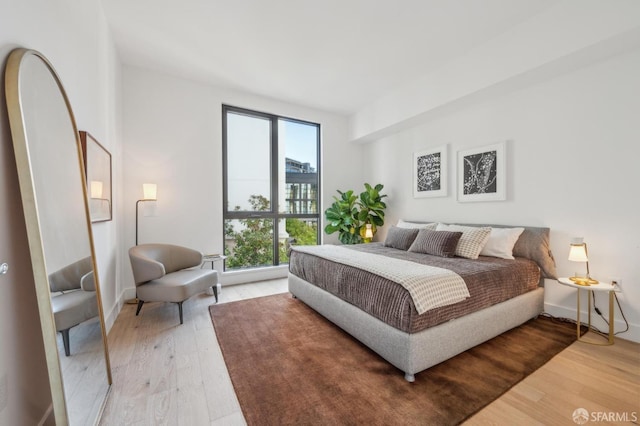 bedroom with baseboards and light wood-style flooring