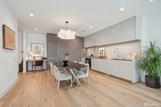 dining space featuring baseboards, wine cooler, recessed lighting, and light wood-type flooring