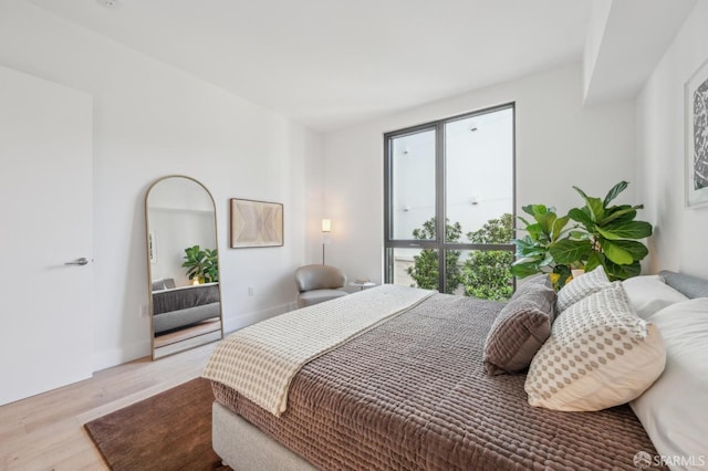 bedroom with baseboards and wood finished floors