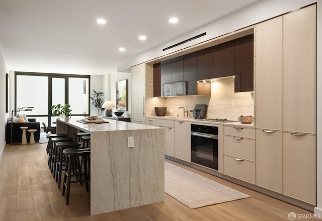 kitchen featuring a kitchen breakfast bar, a kitchen island, stainless steel appliances, and light hardwood / wood-style flooring