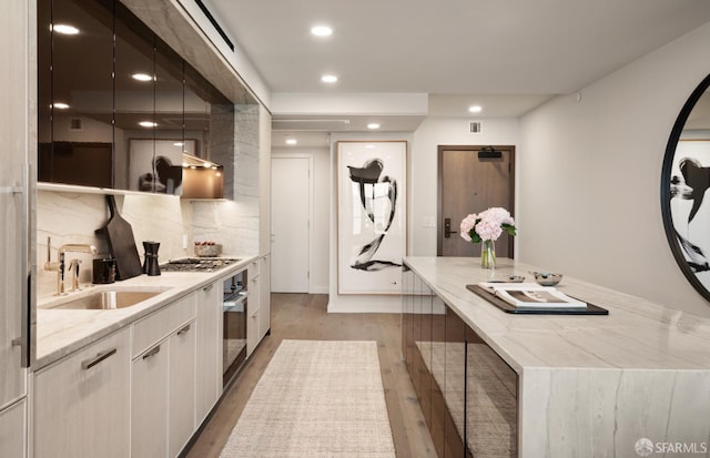 kitchen featuring white cabinets, appliances with stainless steel finishes, light hardwood / wood-style flooring, and sink