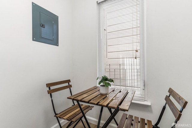 dining space featuring electric panel and baseboards