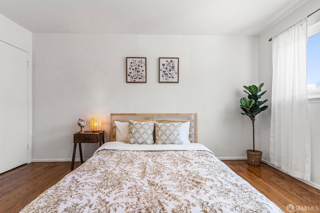 bedroom with baseboards and wood finished floors