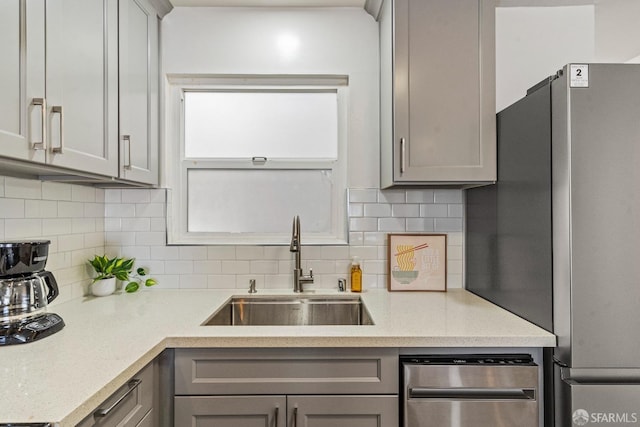 kitchen featuring freestanding refrigerator, gray cabinets, and a sink