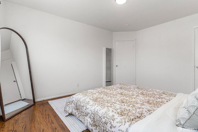 bedroom with wood finished floors and baseboards