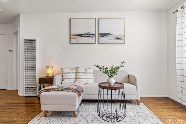 interior space featuring a heating unit, baseboards, and wood finished floors