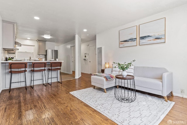 living room featuring baseboards, wood finished floors, and recessed lighting