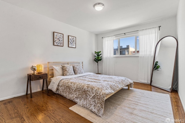 bedroom with baseboards and wood finished floors