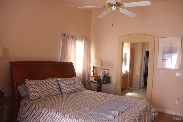 bedroom with baseboards, arched walkways, and ceiling fan