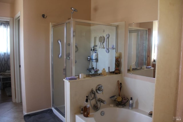 bathroom with a stall shower, a bath, and tile patterned floors