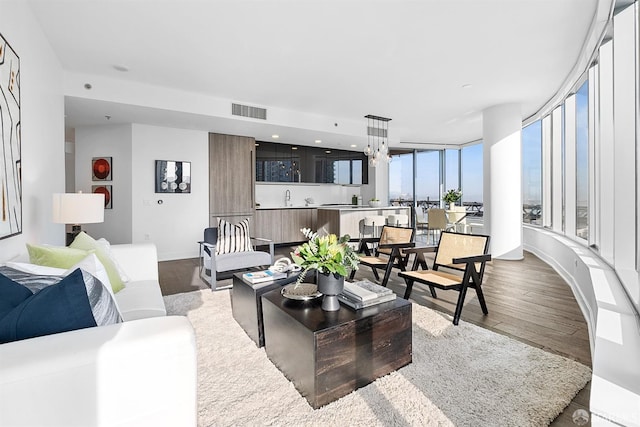 living area with dark wood-type flooring, visible vents, and baseboards