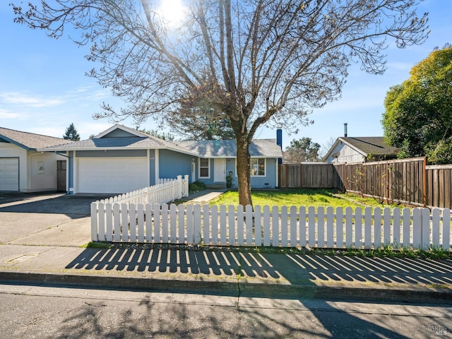 ranch-style house with a fenced front yard, a front yard, driveway, and a garage