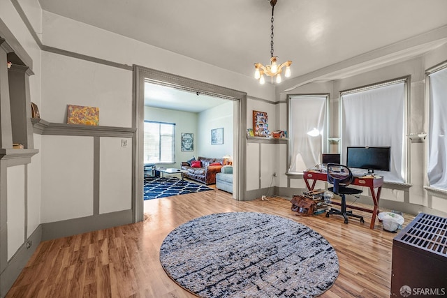 office with wood-type flooring and a notable chandelier