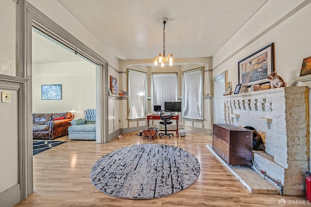 office with light hardwood / wood-style flooring and a chandelier