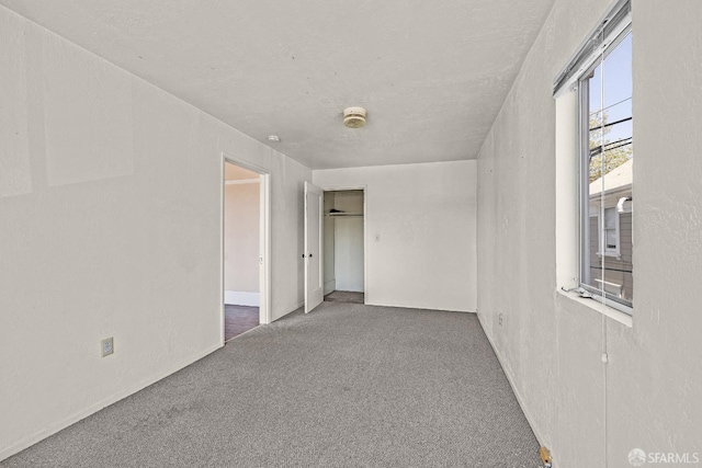 unfurnished room with dark colored carpet