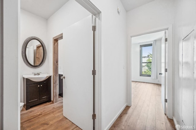 hall featuring light wood-type flooring and sink