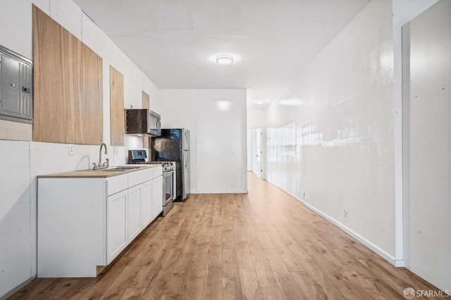 kitchen with white cabinetry, sink, light hardwood / wood-style flooring, and stainless steel appliances