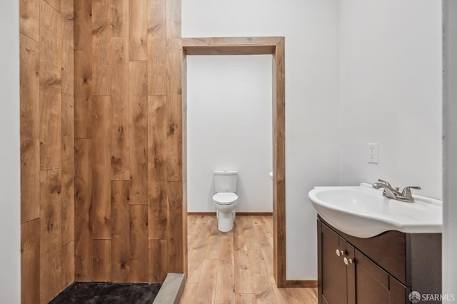 bathroom featuring wood-type flooring, vanity, and toilet