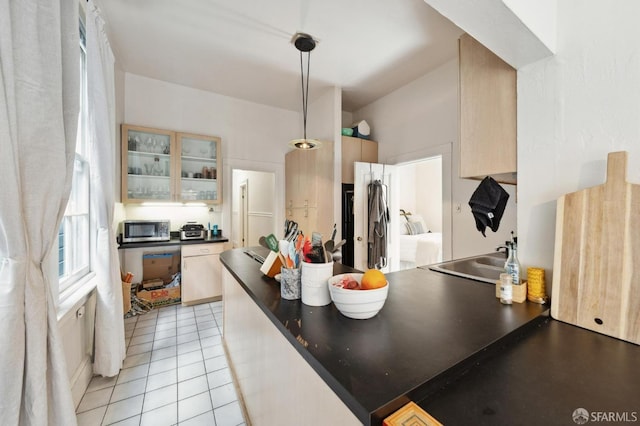 kitchen featuring hanging light fixtures, light tile patterned floors, and sink