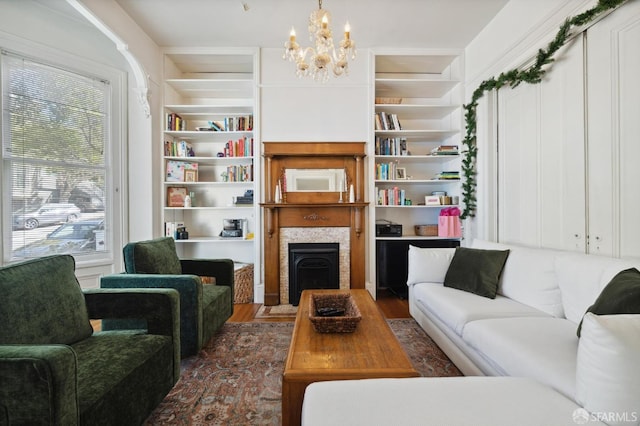 living room featuring built in shelves, dark hardwood / wood-style floors, and an inviting chandelier