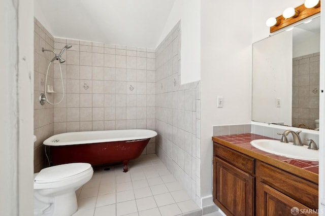 bathroom with tile patterned floors, vanity, tile walls, toilet, and a bathing tub