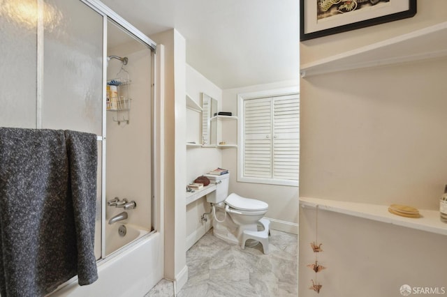 bathroom featuring combined bath / shower with glass door and toilet