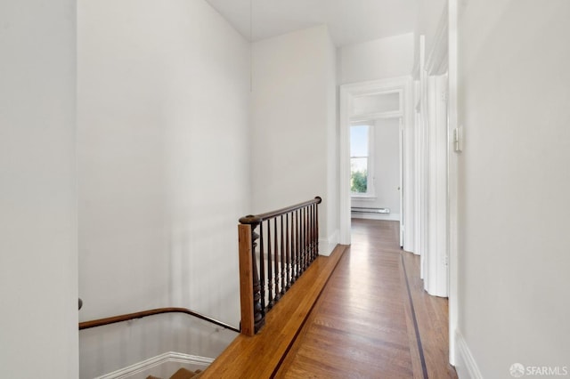 hallway with baseboard heating and hardwood / wood-style floors