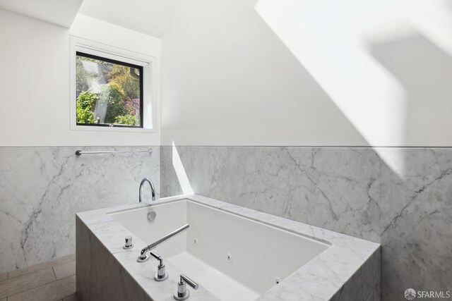 bathroom with tiled bath and tile walls