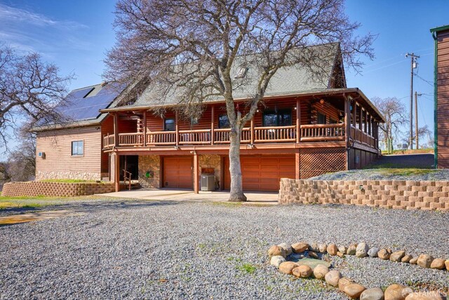 log cabin with central AC, a garage, and a deck