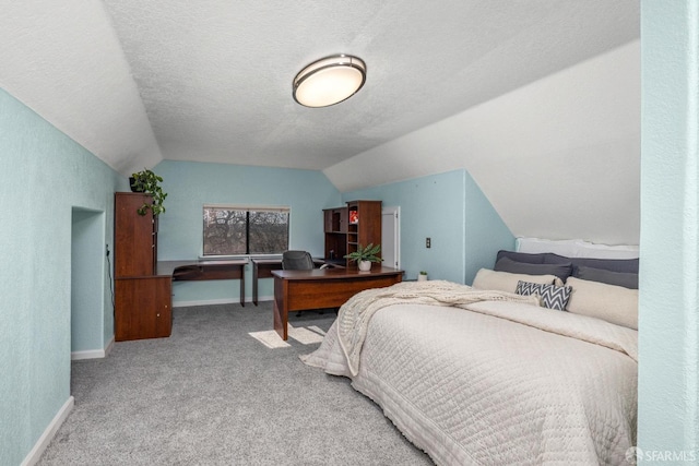 bedroom featuring lofted ceiling, carpet flooring, and a textured ceiling