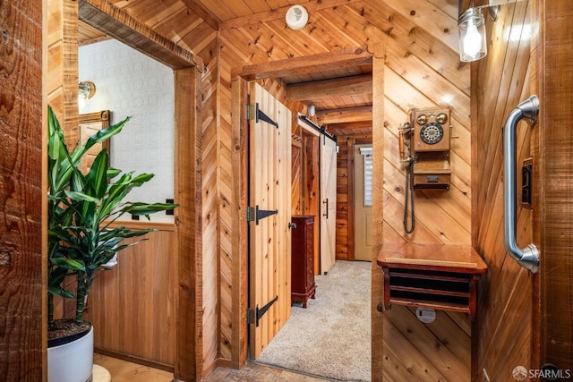 hall with beam ceiling, light carpet, wooden ceiling, and wooden walls