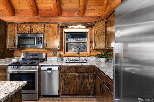 kitchen with appliances with stainless steel finishes, sink, wood ceiling, light stone countertops, and beam ceiling